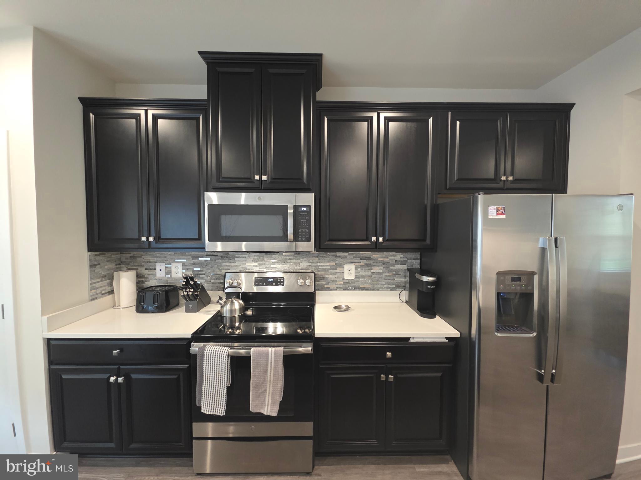 14510 Hunts Farm Road Brandywine, MD 20613 - Photo 27 of 74 a kitchen with stainless steel appliances wooden cabinets and a sink