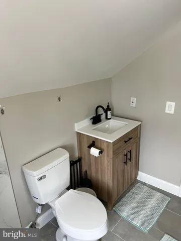 a bathroom with a toilet a sink and mirror