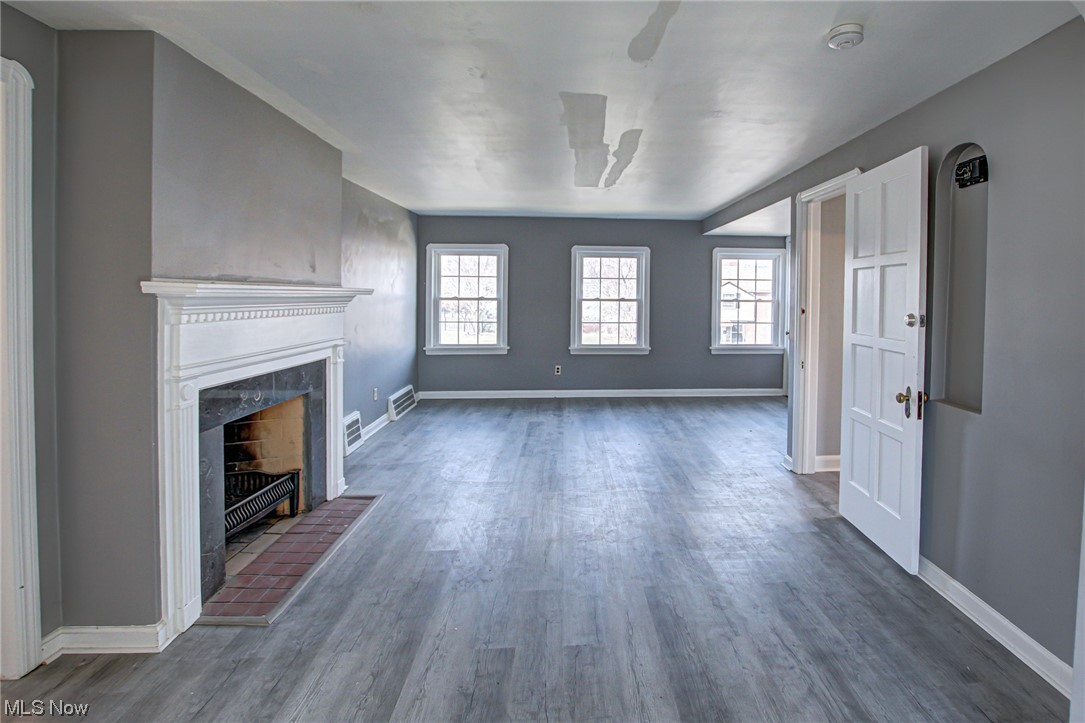 3423 Westbury Road Cleveland, OH 44120 - Photo 7 of 38 Unfurnished living room featuring dark hardwood / wood-style flooring, plenty of natural light, and a brick fireplace