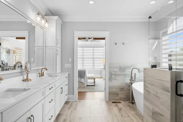 a spacious bathroom with a double vanity sink a mirror and a shower