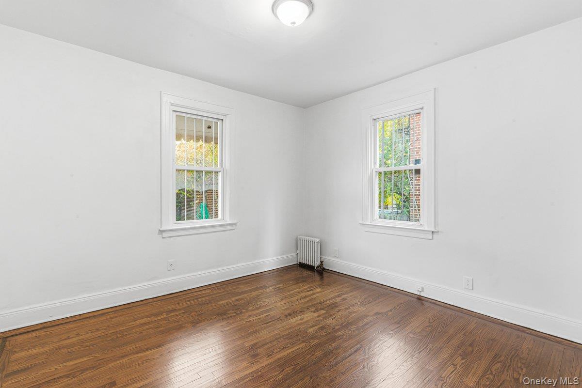 33-43 83rd Street Queens, NY 11372 - Photo 14 of 38 an empty room with wooden floor and windows