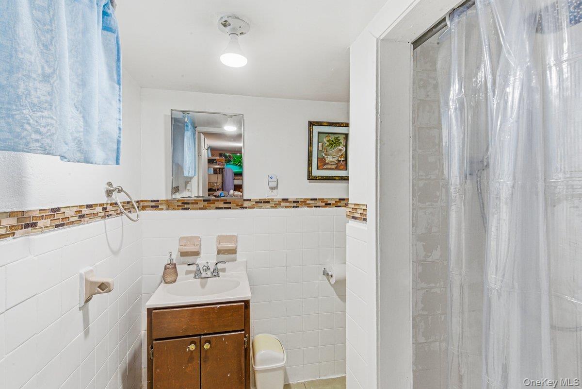 33-43 83rd Street Queens, NY 11372 - Photo 19 of 38 a bathroom with a sink a mirror and a toilet