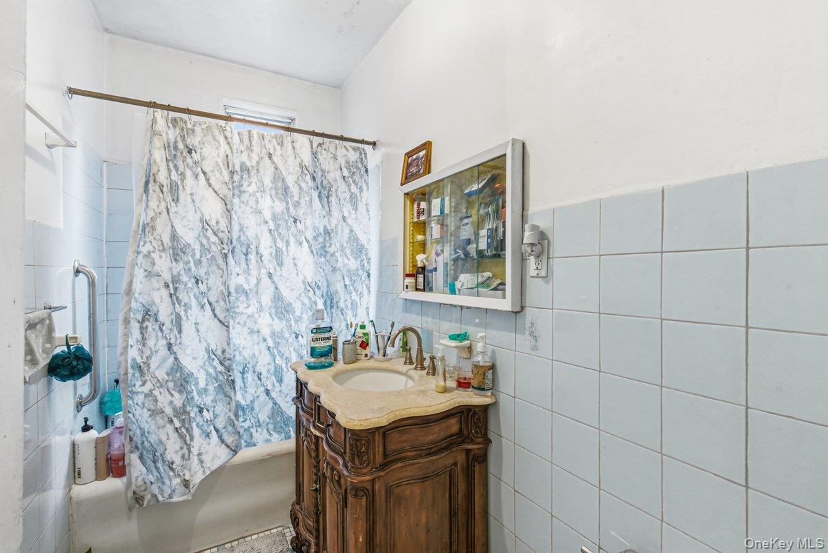 33-43 83rd Street Queens, NY 11372 - Photo 32 of 38 a bathroom with a granite countertop sink a mirror and a shower