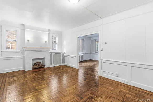 a view of a livingroom with wooden floor and a fireplace