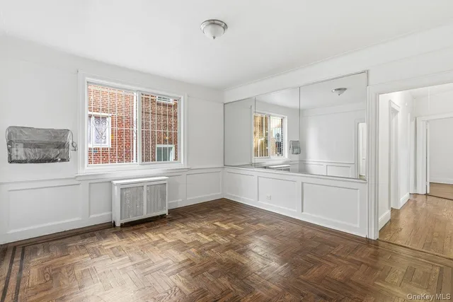 a view of an empty room with window and cabinet