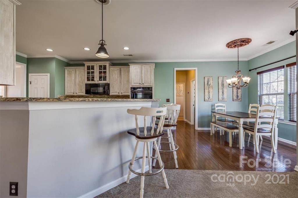 7178 Meyer Road Fort Mill, SC 29715 - Photo 16 of 36 a kitchen with stainless steel appliances kitchen island granite countertop a dining table chairs and granite counter tops