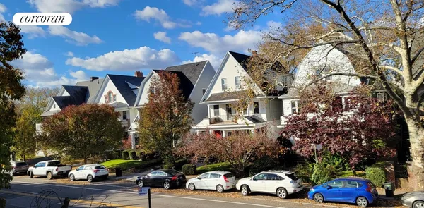 a view of building with cars parked across