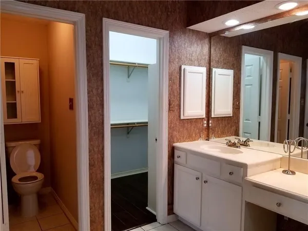 a bathroom with a double vanity sink toilet and a mirror