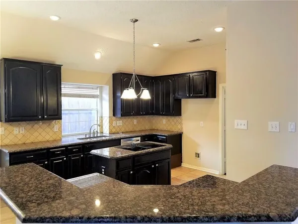 a kitchen with stainless steel appliances granite countertop a sink and a stove