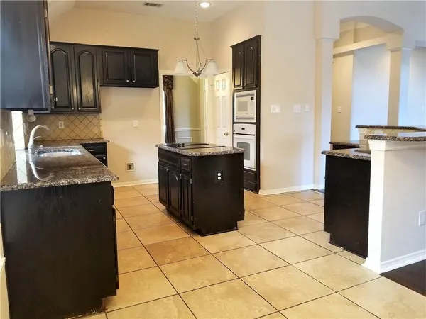 a kitchen with stainless steel appliances granite countertop a refrigerator and a stove