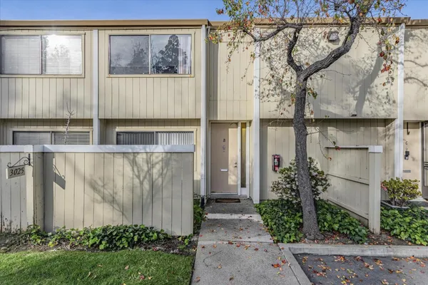 a view of a small house with a tree in front of it