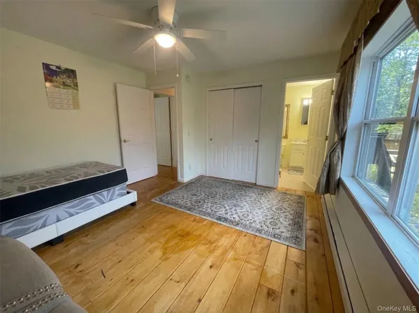 a spacious bedroom with a bed and wooden floor