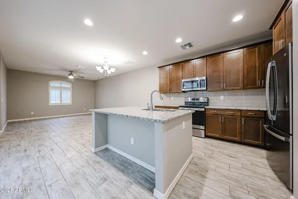 a kitchen with stainless steel appliances granite countertop a stove a sink and a refrigerator