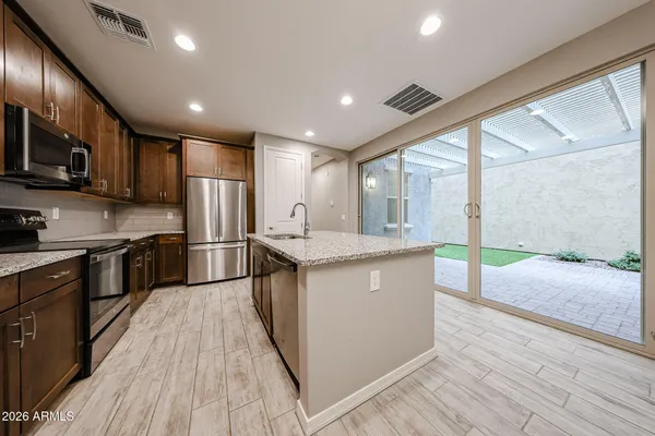 a kitchen with stainless steel appliances granite countertop a stove a sink and a refrigerator