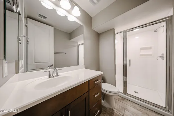 a bathroom with a sink a toilet and shower