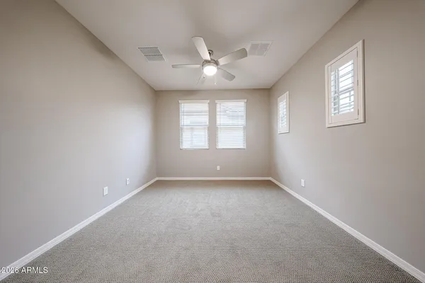an empty room with a window and a ceiling fan
