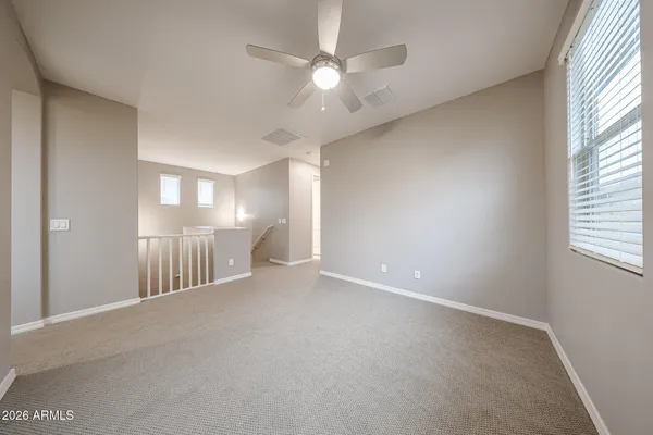 a view of a room with a ceiling fan and window