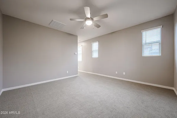 an empty room with windows and fan