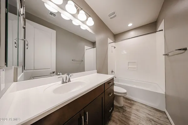a bathroom with a sink a toilet a mirror and shower