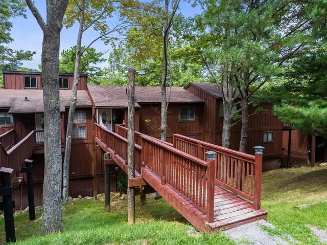 an aerial view of residential houses with outdoor space and trees