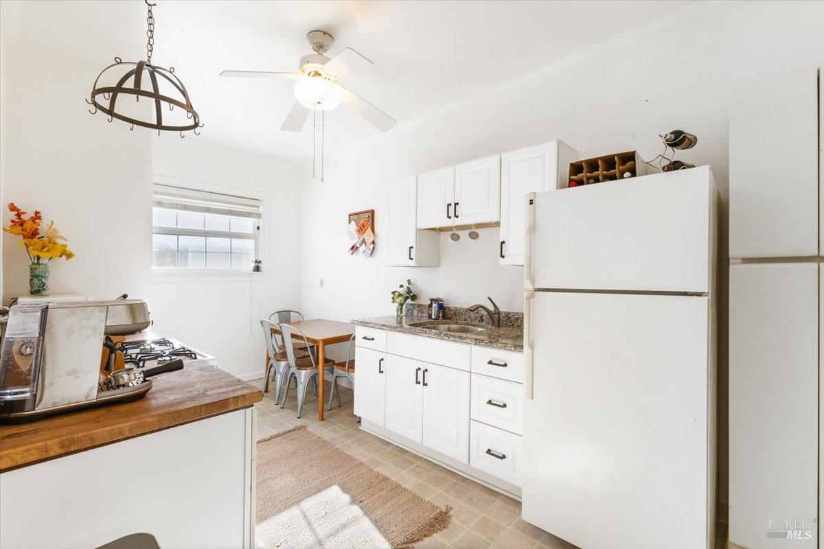 320 Center Street Healdsburg, CA 95448 - Photo 35 of 56 a kitchen with granite countertop a refrigerator a stove a sink dishwasher and white cabinets with wooden floor