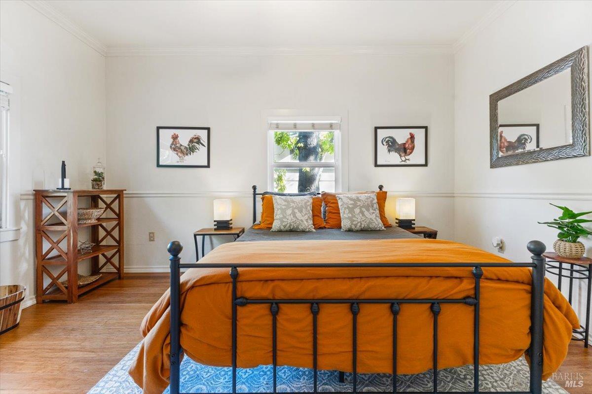 320 Center Street Healdsburg, CA 95448 - Photo 49 of 56 a bedroom with a bed and dresser with paintings on wall