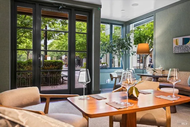 a living room with couches and kitchen view with wooden floor