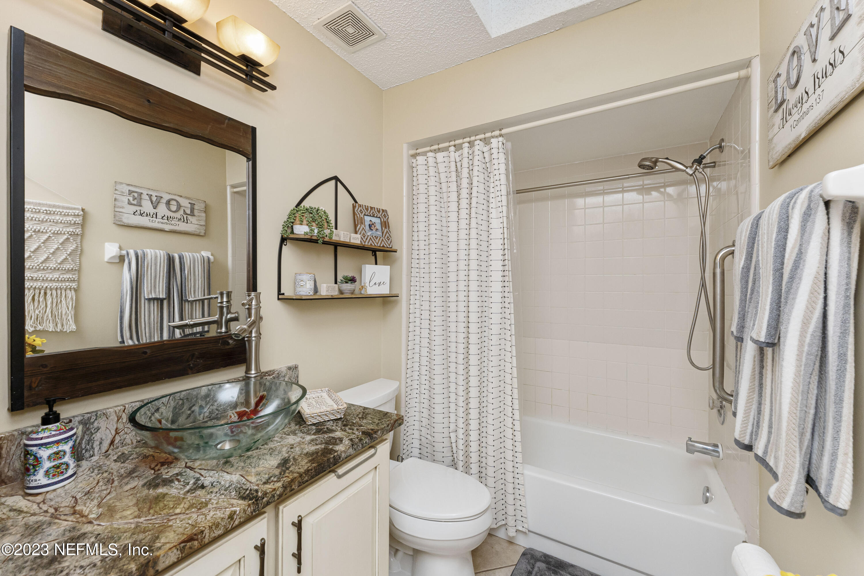 1676 Westwind Drive Jacksonville Beach, FL 32250 - Photo 18 of 42 a bathroom with a granite countertop sink toilet and shower