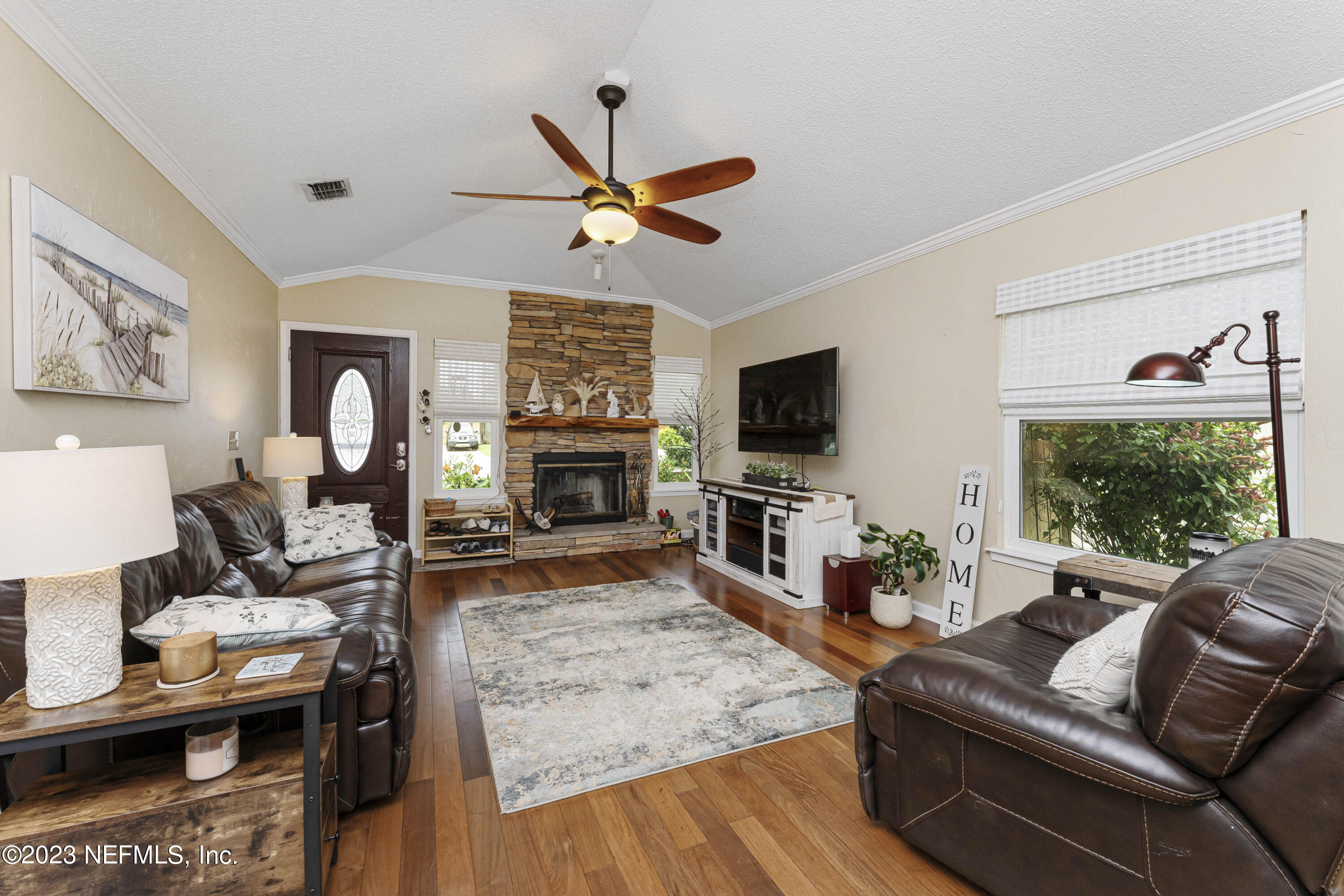 1676 Westwind Drive Jacksonville Beach, FL 32250 - Photo 5 of 42 a living room with furniture a fireplace and a flat screen tv
