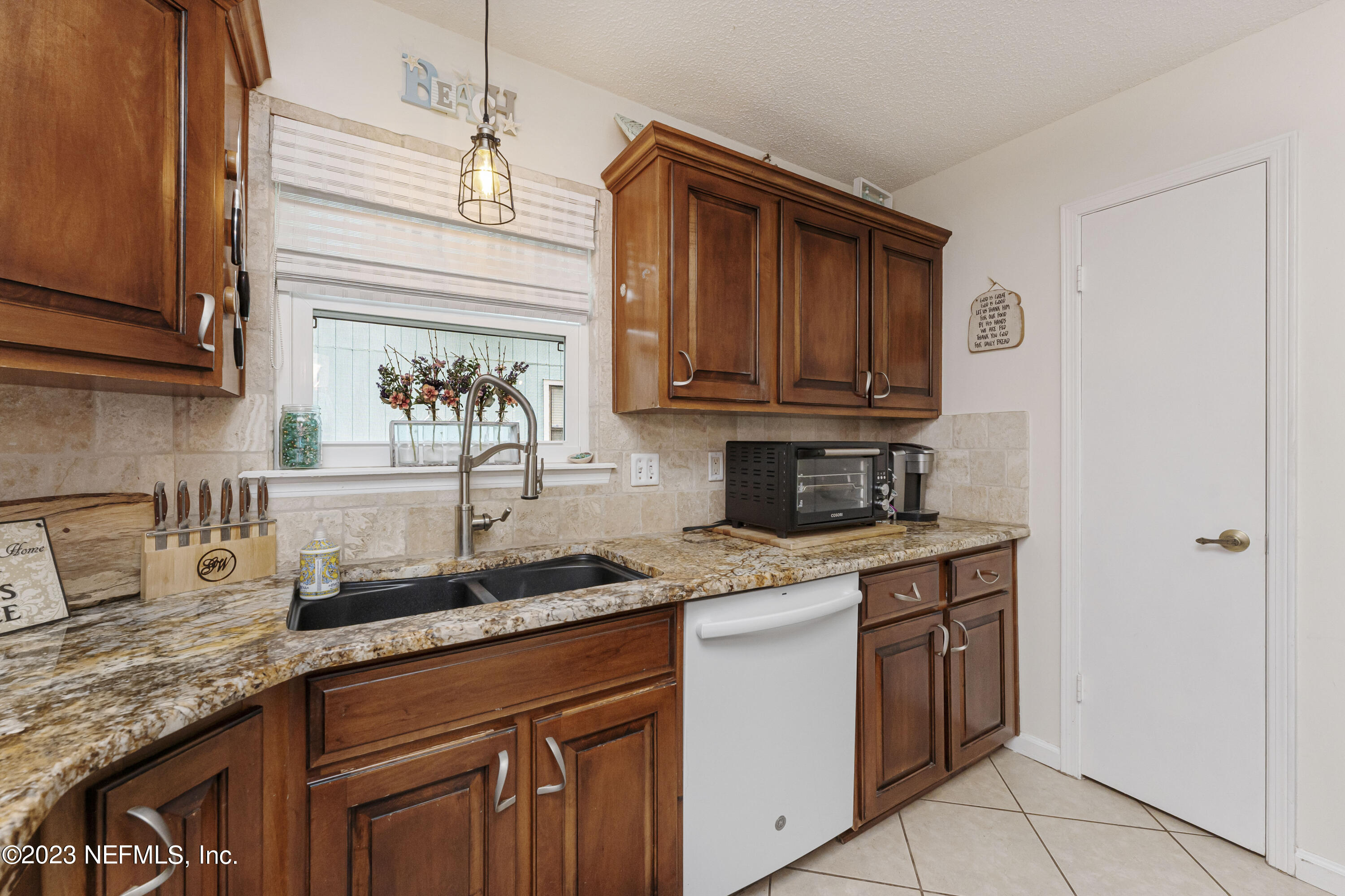 1676 Westwind Drive Jacksonville Beach, FL 32250 - Photo 10 of 42 a kitchen with stainless steel appliances granite countertop a sink and cabinets