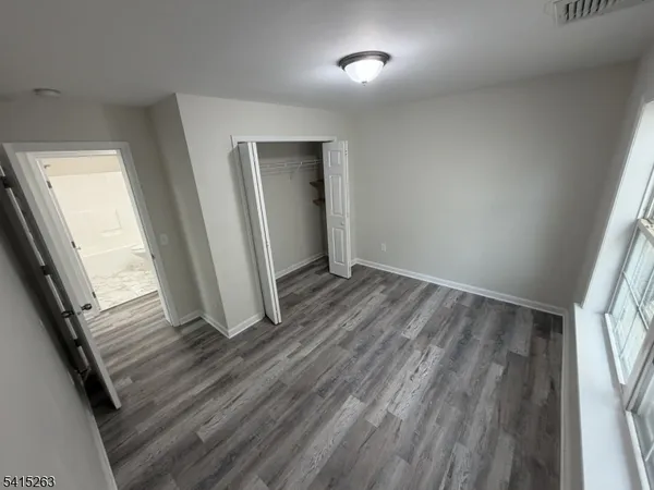 an empty room with wooden floor and entrance