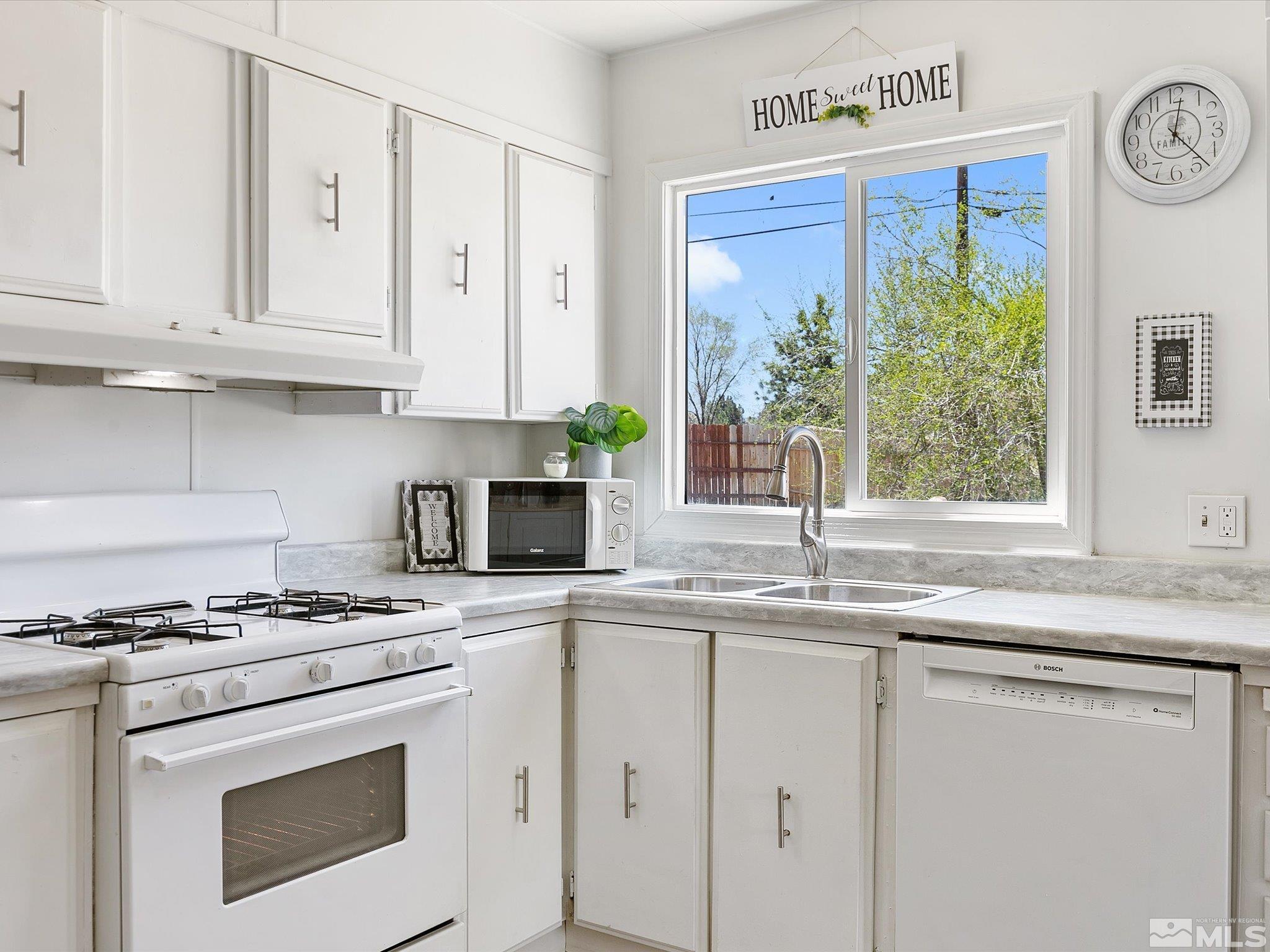 17560 Thrush Lane Reno, NV 89508 - Photo 5 of 27 a kitchen with granite countertop white cabinets and white appliances
