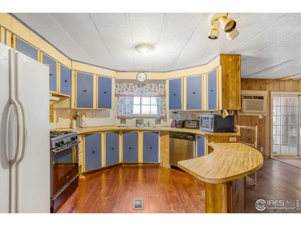 a kitchen with stainless steel appliances granite countertop a sink refrigerator and cabinets