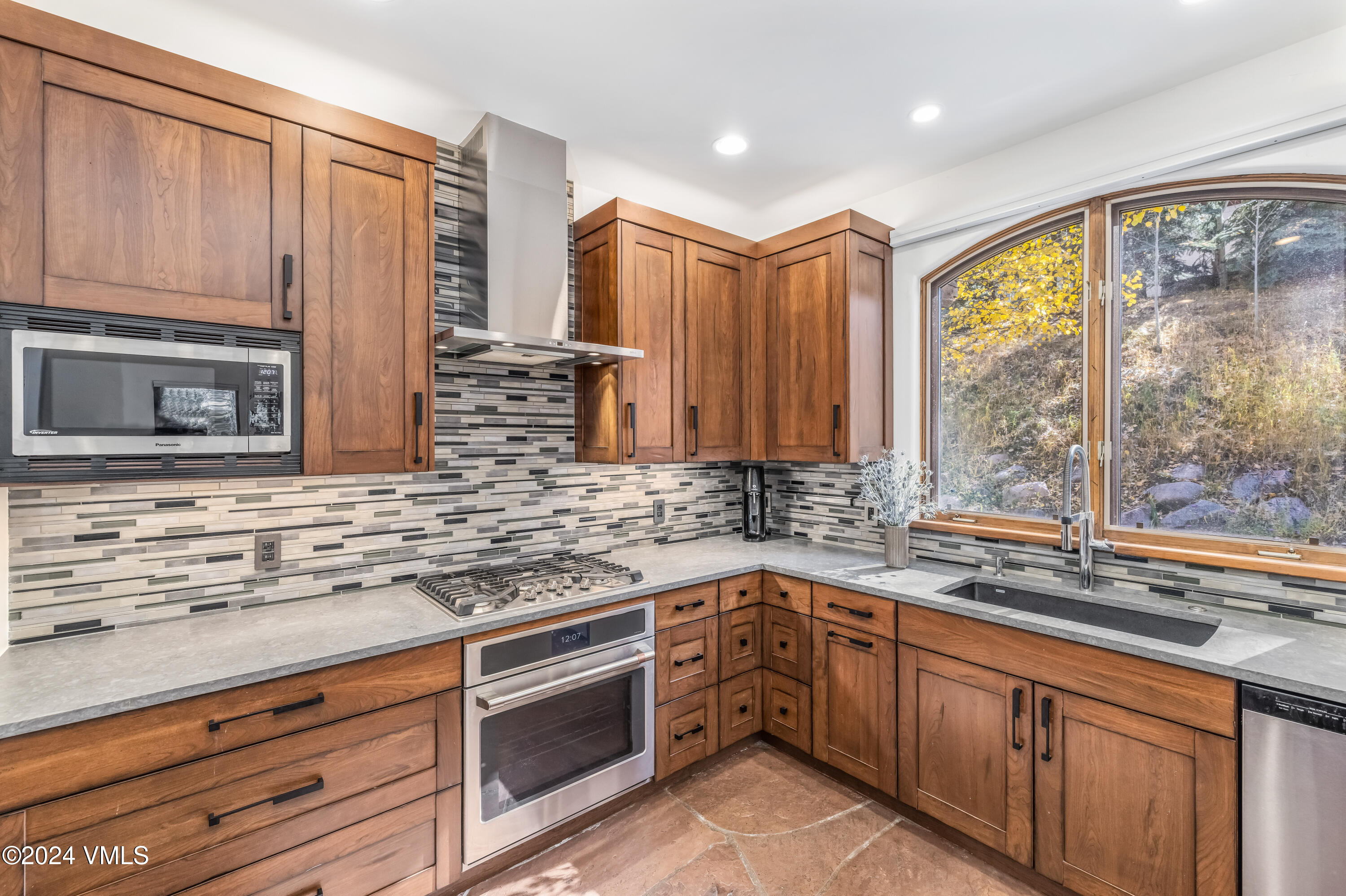 2076 Vermont Road Vail, CO 81657 - Photo 12 of 39 a kitchen with stainless steel appliances granite countertop a sink a stove and a microwave