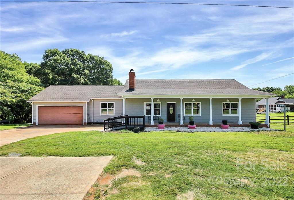 a front view of a house with a yard and trees