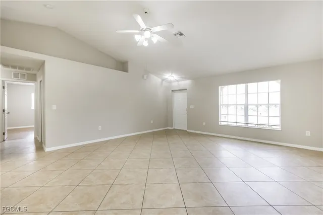 an empty room with a ceiling fan and a window