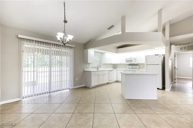 a kitchen with white cabinets and white appliances