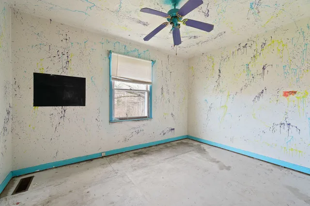 a view of an empty room with a window and a flat screen tv