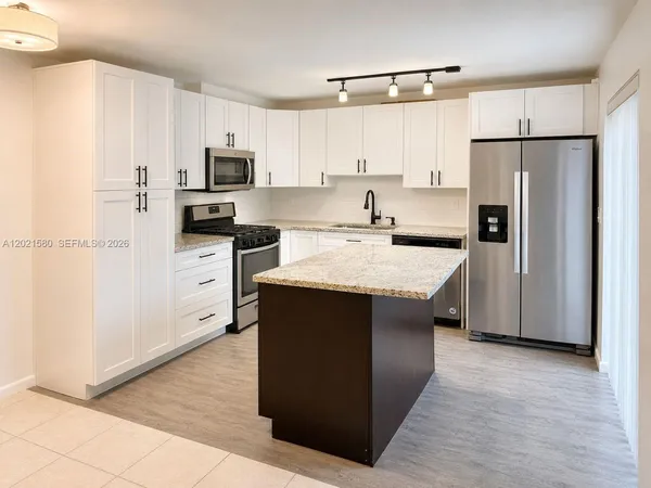 a kitchen with stainless steel appliances granite countertop a refrigerator stove microwave and sink