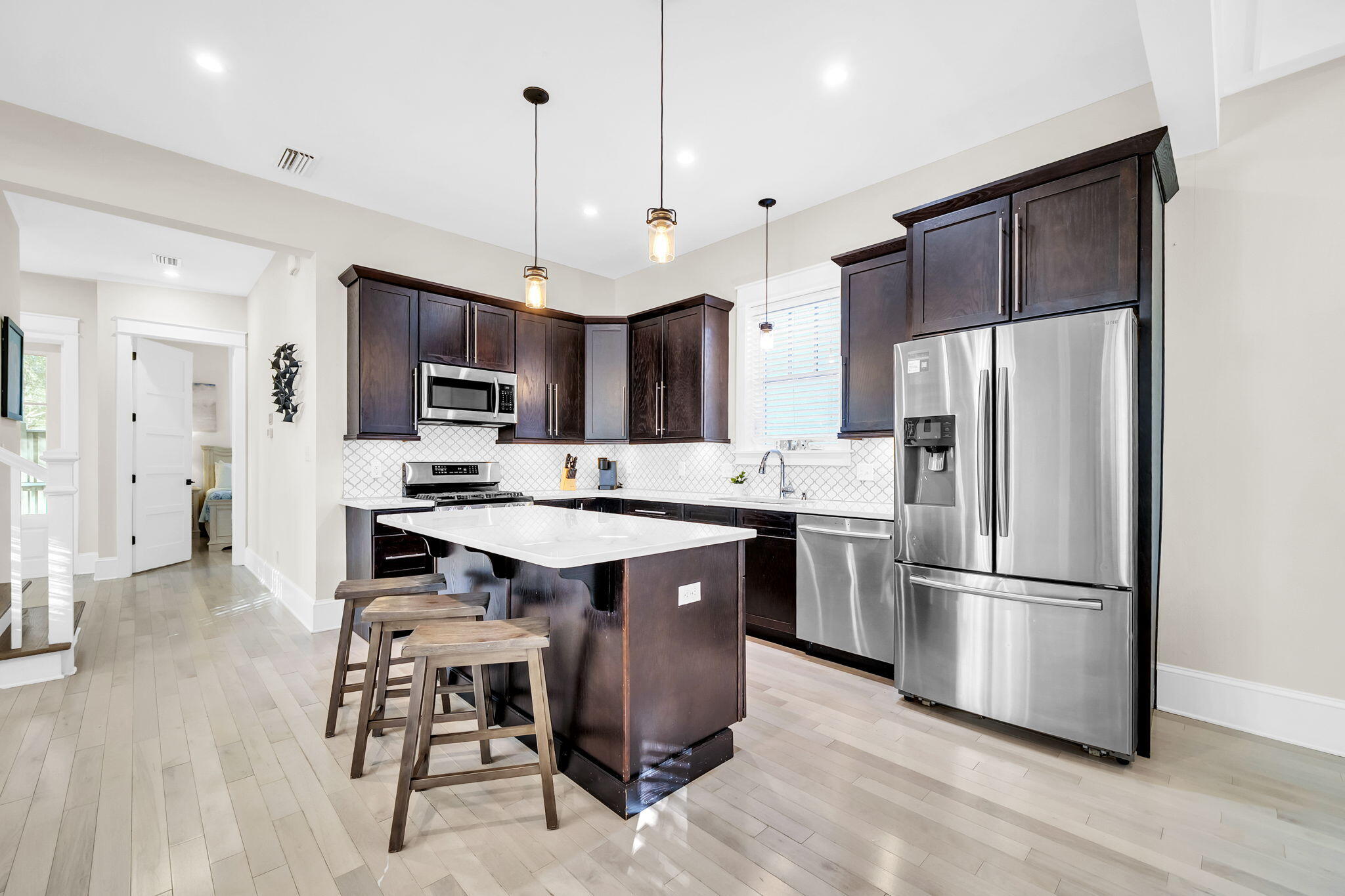 13 Eastern Lake Court Santa Rosa Beach, FL 32459 - Photo 13 of 58 a kitchen with kitchen island granite countertop stainless steel appliances a sink a stove a refrigerator cabinets and wooden floor