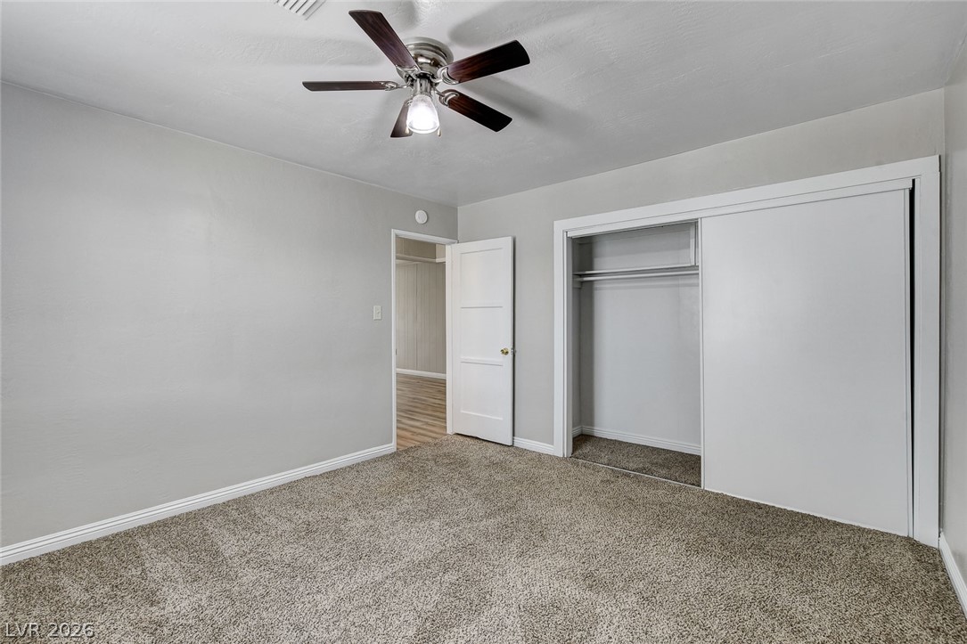 214 West Victory Road Henderson, NV 89015 - Photo 16 of 33 Comfortable carpeted bedroom featuring a practical sliding closet and ceiling fan.