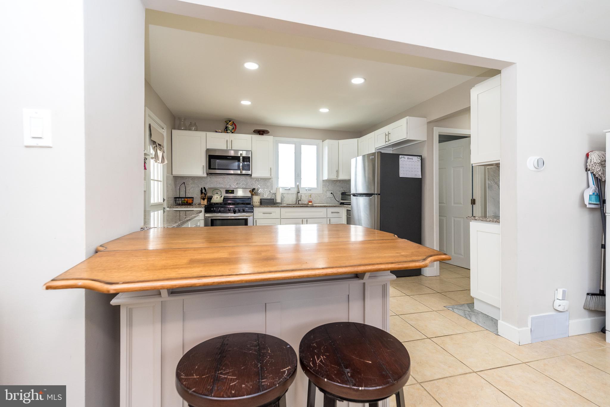 253 Luff Lane Warminster, PA 18974 - Photo 11 of 30 a kitchen with a refrigerator and a stove top oven with white cabinets