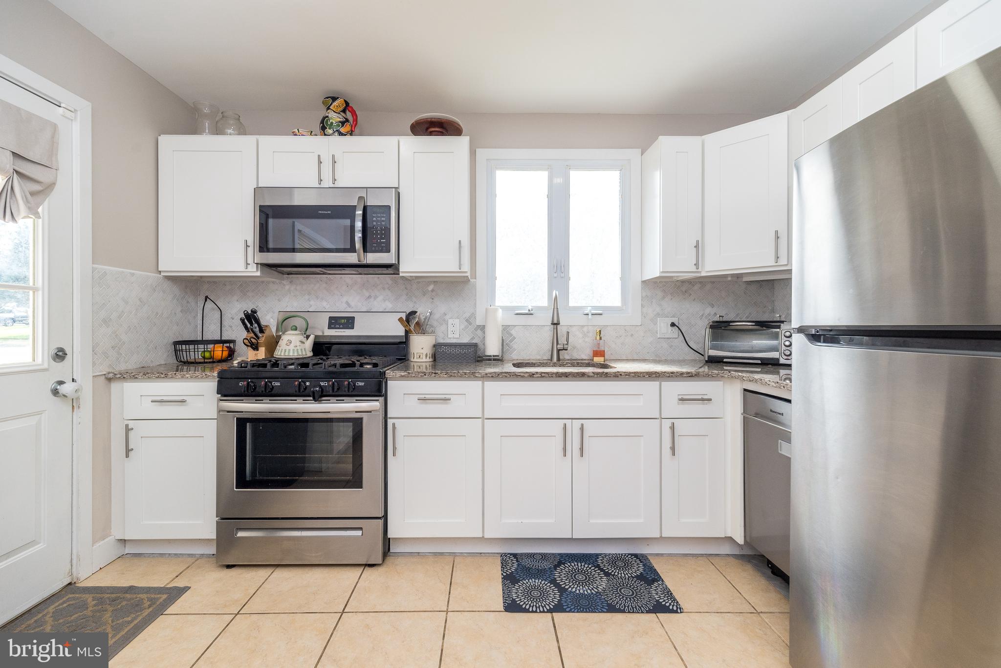 253 Luff Lane Warminster, PA 18974 - Photo 6 of 30 a kitchen with white cabinets a sink and white appliances
