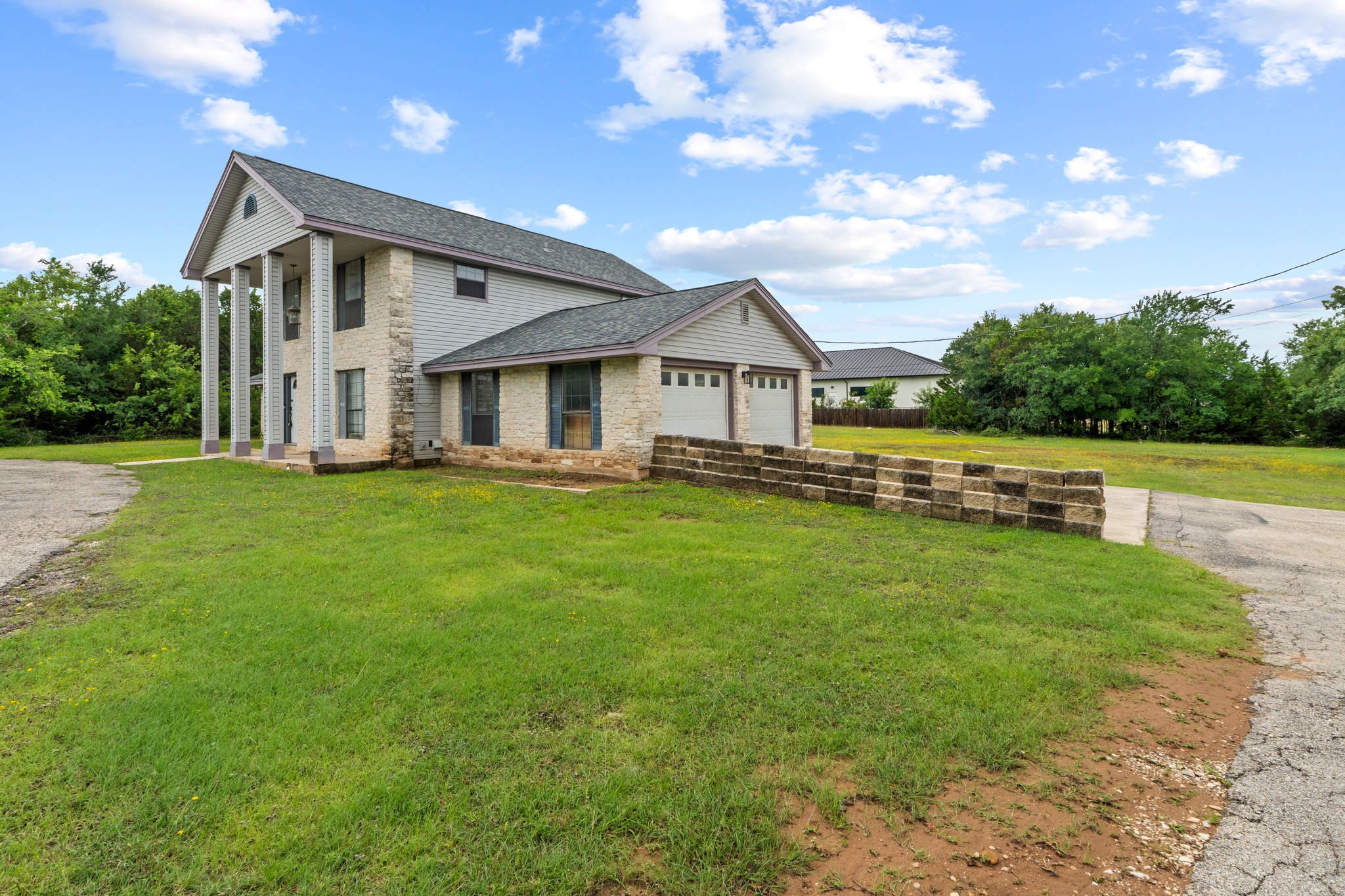 205 Sedro Trail Georgetown, TX 78633 - Photo 2 of 32 A spacious home with stone accents and an attached garage offers ample outdoor space.