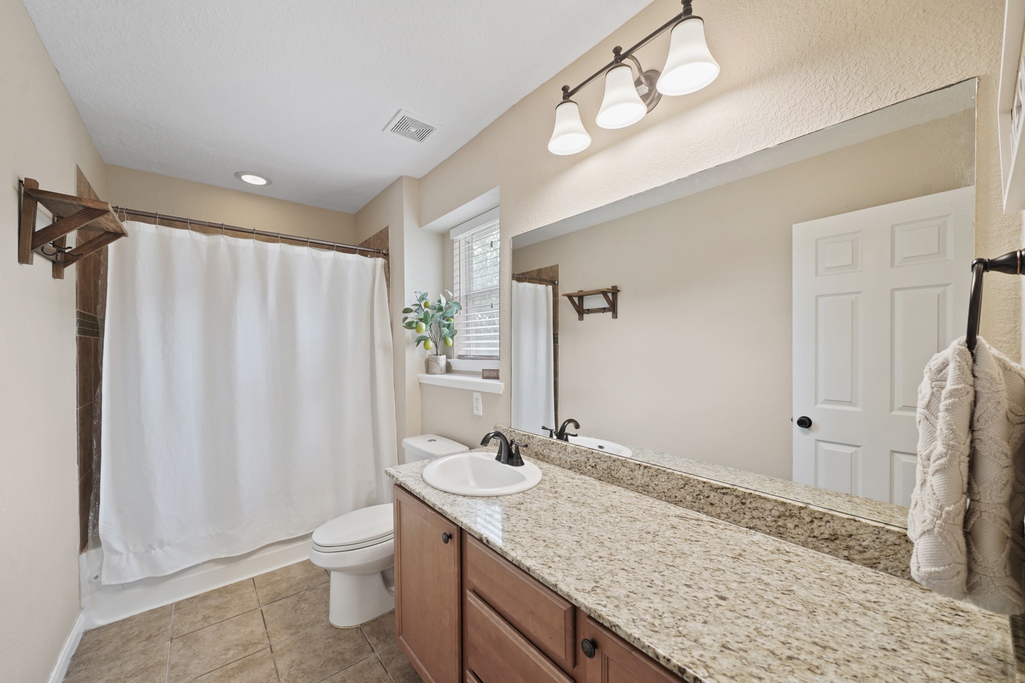 2502 J. R. Drive Manvel, TX 77578 - Photo 25 of 31 a bathroom with a granite countertop sink and a mirror