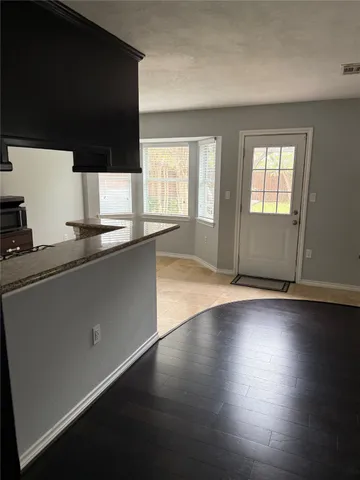 an open kitchen with wooden floor and large window