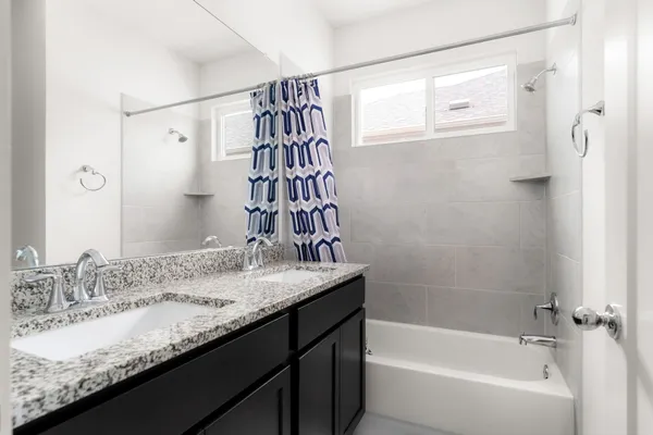 a bathroom with a granite countertop sink a mirror a shower and a bathtub