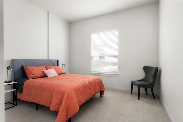 a bedroom with a bed and chair