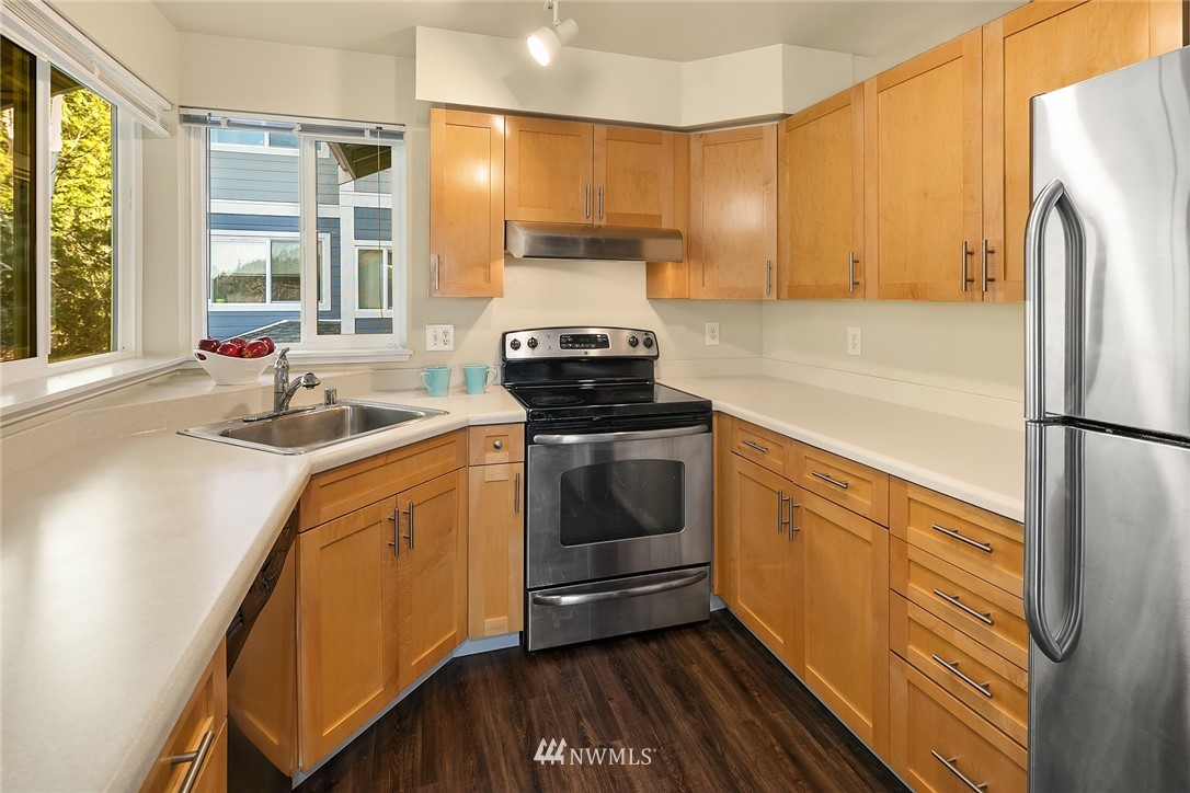 3926 243rd Place Southeast, Unit H301 Bothell, WA 98021 - Photo 5 of 16 a kitchen with a sink stove and refrigerator