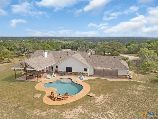 an aerial view of a house with yard swimming pool and outdoor seating